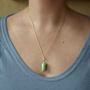 Monarch chrysalis glass necklace with 24k gold dots worn by artist Jude Rose. www.juderose.com