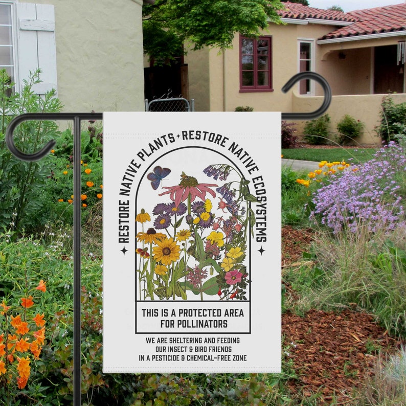 May include: A white garden flag with a colourful illustration of wildflowers and a butterfly. The text reads "Restore Native Plants Restore Native Ecosystems. This is a protected area for pollinators. We are sheltering and feeding our insect and bird friends in a pesticide and chemical-free zone."