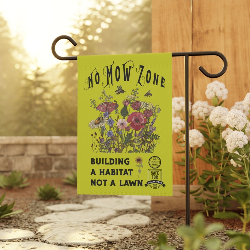 K&ouml;nnte beinhalten: Eine Gartenflagge mit dem Text "NO MOW ZONE" und "BUILDING A HABITAT NOT A LAWN" auf chartreusefarbenem Hintergrund. Die Flagge zeigt eine Blumenillustration mit Bienen und den Worten "SAFE FOR POLLINATORS". Die Flagge wird auf einem schwarzen Metallst&auml;nder pr&auml;sentiert.