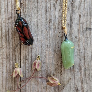 Two Monarch chrysalis glass necklaces with 24k gold dots made by artist Jude Rose. www.juderose.com