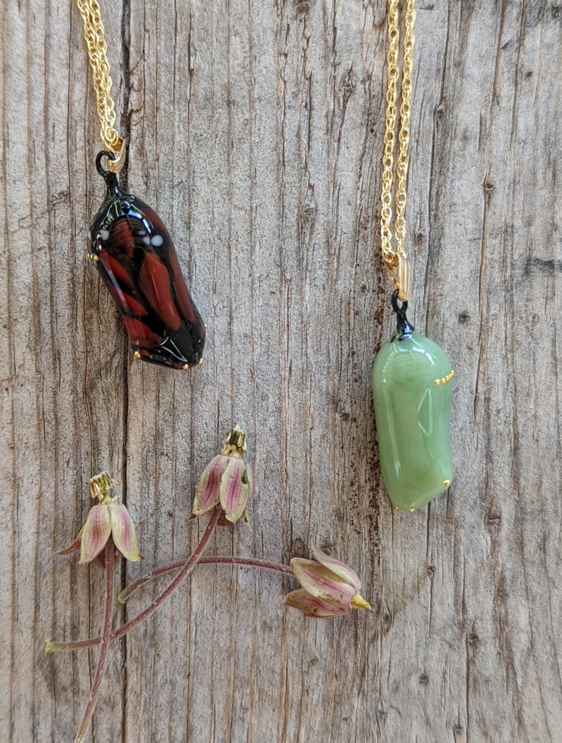 Two Monarch chrysalis glass necklaces with 24k gold dots made by artist Jude Rose. www.juderose.com
