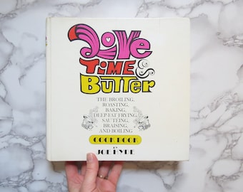 Könnte beinhalten: Ein Vintage-Kochbuch mit dem Titel "Love Time & Butter" in einer farbenfrohen, verspielten Schrift. Das Buch behandelt die Garmethoden Braten, Rösten, Backen, Frittieren, Anbraten, Schmoren und Kochen. Der Autor ist Joe Hyde.
