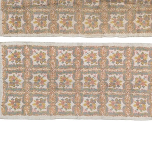 May include: Two rectangular rugs with a floral pattern in shades of pink, yellow, and green. The rugs have a white background and a border of a darker shade of white.