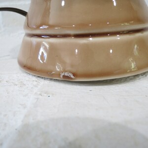 May include: A brown ceramic lamp base with a slightly chipped bottom.