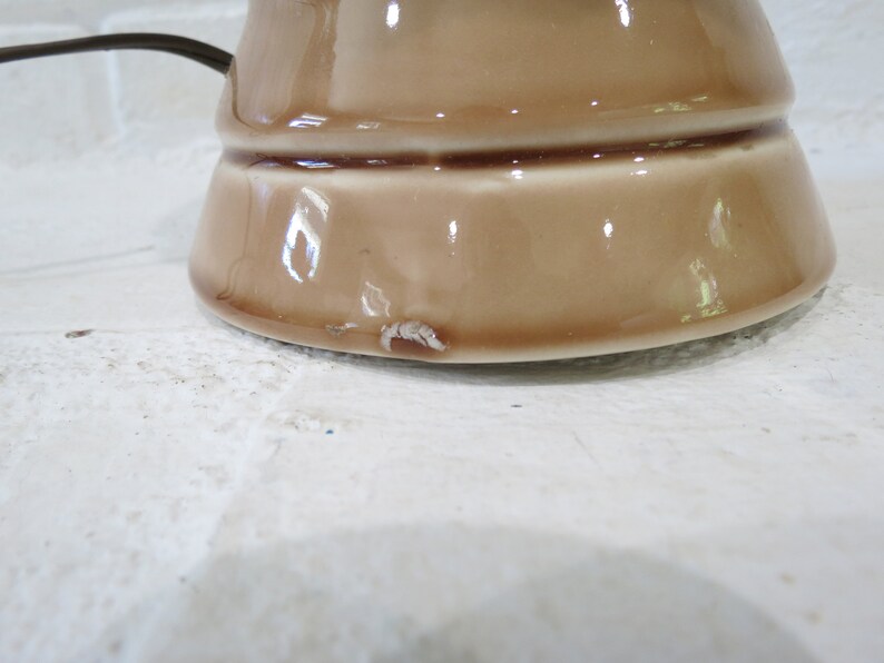 May include: A brown ceramic lamp base with a slightly chipped bottom.