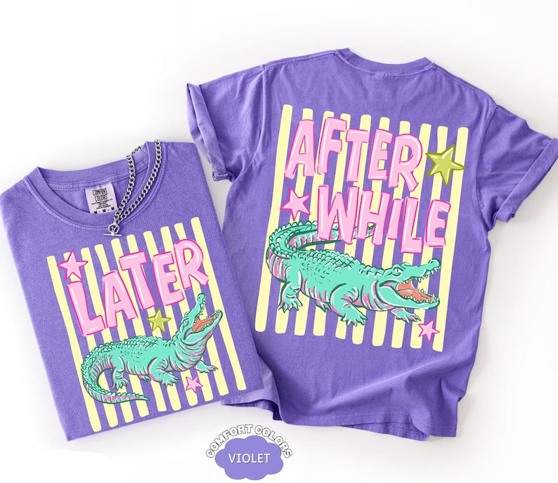 May include: Two violet t-shirts with a graphic design. One shirt reads "LATER" and the other reads "AFTER WHILE" in pink letters. Both shirts feature a teal alligator illustration and yellow stripes.