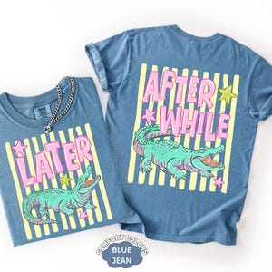 May include: Two blue jean-colored t-shirts with matching designs. The front shirt says "LATER" in pink letters with a green alligator graphic. The back shirt says "AFTER WHILE" with a matching alligator graphic.