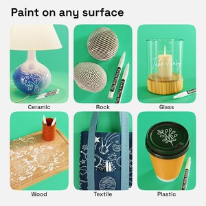 May include: A set of white extra fine tip paint markers shown decorating various surfaces including a ceramic lamp, rocks, a glass candle holder with the text Take it easy, a wooden cutting board, a blue textile tote bag, and a plastic cup lid.