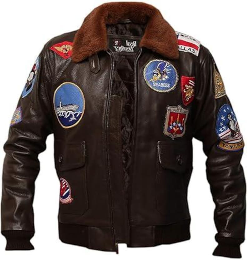 May include: A brown leather jacket with a brown fur collar and multiple patches. The jacket has a zipper closure, two front pockets, and ribbed cuffs and hem. Patches include military-themed designs and text.