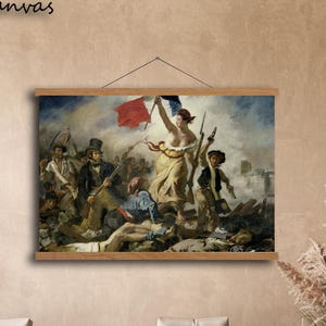 May include: A framed canvas print of a historical painting, depicting a battle scene with a central female figure holding a flag. The artwork is mounted on a wooden frame and hangs on a neutral wall. The text "Hanging Canvas" is visible at the top.