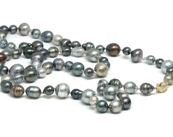 Può includere: Una lunga collana di perle nere, grigie e marroni con una chiusura dorata. Le perle sono di diverse dimensioni e forme, creando un look unico ed elegante.