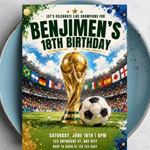 May include: A rectangular birthday invitation card featuring a gold trophy and a soccer ball on a green field inside a stadium. The text reads: LET'S CELEBRATE LIKE CHAMPIONS FOR BENJIMEN'S 18TH BIRTHDAY, SATURDAY, JUNE 18TH | 6PM, 123 ANYWHERE ST, ANY CITY, RSVP TO DAVID AT 123 123 4567.