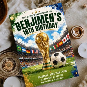 May include: A rectangular birthday invitation card featuring a gold trophy and a soccer ball on a green field inside a stadium. The text reads: LET'S CELEBRATE LIKE CHAMPIONS FOR BENJIMEN'S 18TH BIRTHDAY, SATURDAY, JUNE 18TH | 6PM, 123 ANYWHERE ST, ANY CITY, RSVP TO DAVID AT 123 123 4567.