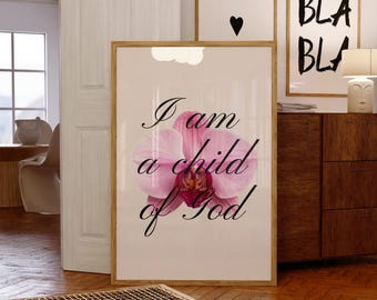 Peut inclure: Une affiche encadrée rectangulaire représentant une grande orchidée rose vif centrée sur un fond blanc. Le texte noir en cursive superposé sur la fleur indique, I am a child of God. Le cadre est en bois de couleur claire.