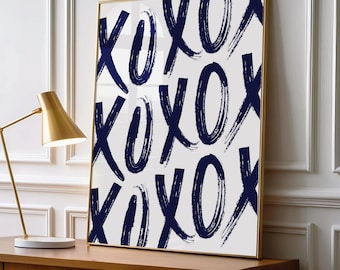 May include: A rectangular framed wall art piece featuring a repeating pattern of dark navy blue hand-painted style X and O characters on a crisp white background. The artwork is encased in a thin gold metal frame, displaying a bold graphic design.