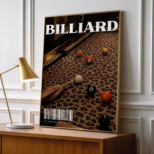 May include: A rectangular wall art print featuring the word BILLIARD in white text at the top. The image shows a pool table with a leopard print felt surface, several coloured billiard balls, and a cue stick. A barcode is printed at the bottom.