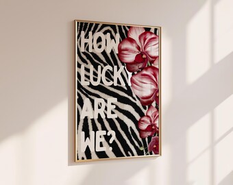 Peut inclure: Une affiche encadrée rectangulaire présentant un fond à rayures zébrées noires et blanches. Le texte HOW LUCKY ARE WE? est imprimé en grandes lettres blanches sur la gauche, tandis que des orchidées roses et rouges fleurissent à droite.