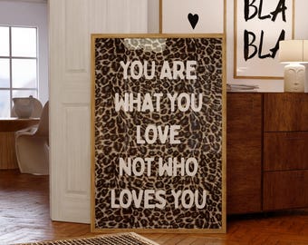 Décoration murale « Tu es ce que tu aimes », typographie blanche audacieuse sur fond imprimé léopard marron, style maximaliste et inspirant, sans cadre