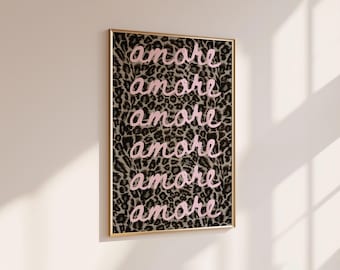 Peut inclure: Une œuvre d'art murale rectangulaire encadrée présentant un motif répétitif du mot amore écrit en écriture cursive rose clair sur un fond imprimé léopard noir, gris et beige, dans un cadre en métal doré fin.