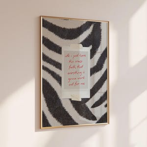 May include: A rectangular framed wall art piece featuring a black and white zebra stripe pattern background. Centered on the print is a light gray rectangular note attached with tape, displaying the red handwritten text: idk i just have this crazy faith that everything is gonna work out for me.