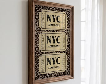Peut inclure: Une œuvre d'art murale encadrée présentant trois billets dorés NYC Admit One avec le numéro de série 7996796, sur un fond à motif léopard marron et noir, le tout dans un cadre en bois marron foncé.