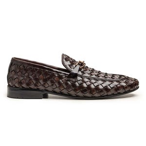 May include: A dark brown loafer featuring a woven leather upper with a glossy finish. The shoe includes a smooth leather strap across the vamp adorned with a small, metallic gold-toned horsebit detail and a low, flat black heel.