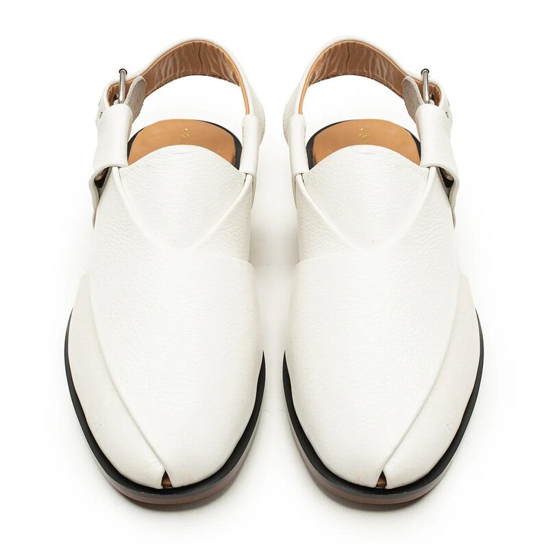 Op de afbeelding: Een paar witte leren sandalen met een puntig teenontwerp. De sandalen hebben een enkelband en een gespsluiting. De zolen zijn zwart met een bruine rand.