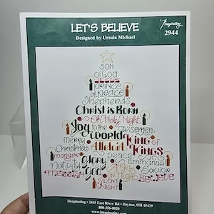 May include: A cross-stitch pattern titled "Let's Believe" with a Christmas tree design made of religious words. The design includes phrases like "Son of God," "Jesus," and "King of Kings." The pattern is designed by Ursula Michael.