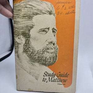 May include: Vintage paperback book titled "Study Guide to Matthew" by William Coble. The cover features a black and white illustration of a man with a beard against an orange background. Handwritten text is visible on the top right corner.