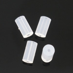 May include: Four clear plastic tubes, each with a round opening at one end. The tubes are arranged in a cross shape on a black surface.