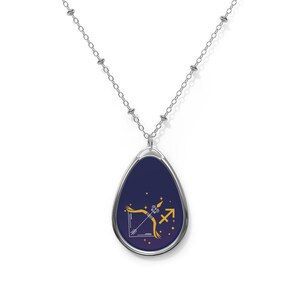 May include: Silver-toned necklace with an oval pendant featuring a Sagittarius zodiac symbol. The pendant has a dark blue background with a gold bow and arrow design and a gold Sagittarius symbol.