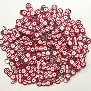 Puede incluir: Una gran colección de llaveros rojos y blancos, cada uno con un patrón repetitivo de la letra H y un círculo. Estas pequeñas piezas de plástico planas, circulares y rectangulares, están conectadas por finas cadenas de bolas de metal plateado.