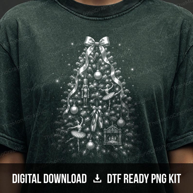 May include: A dark green mineral-washed t-shirt featuring a silver graphic of a Christmas tree decorated with a nutcracker, ballet dancers, pointe shoes, and ornaments. The design includes a large silver bow at the top and sparkling light effects.