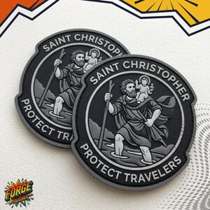 May include: Two circular grey and black patches featuring a raised relief design of Saint Christopher carrying a child on his shoulder while holding a staff. The text SAINT CHRISTOPHER PROTECT TRAVELERS is embossed along the border of each patch.