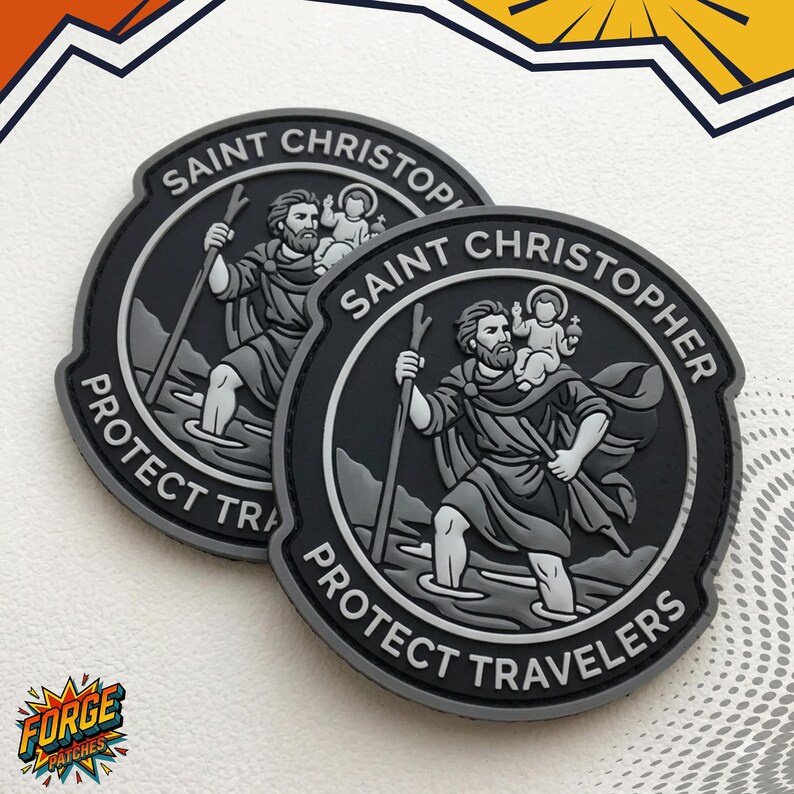 May include: Two circular grey and black patches featuring a raised relief design of Saint Christopher carrying a child on his shoulder while holding a staff. The text SAINT CHRISTOPHER PROTECT TRAVELERS is embossed along the border of each patch.