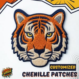 Puede incluir: Parche de chenilla bordado con cabeza de tigre en naranja, azul marino y crema. El parche presenta un diseño detallado con ojos amarillos y el texto "CUSTOMIZED CHENILLE PATCHES". El parche tiene un aspecto texturizado y en relieve.