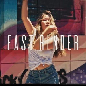 May include: A person in a white top and denim shorts is dancing in front of a colorful graffiti wall. The words "FAST RENDER" are displayed in large white letters. The background features a mix of blue, pink, and purple hues.