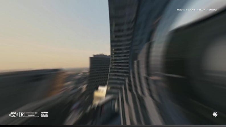 以下が含まれることがあります： 高層ビルと夕焼けの空が写った、ぼやけた都市景観の画像。 上部にウェブサイトのナビゲーションバー、下部にロゴがあり、動きを感じさせる画像です。