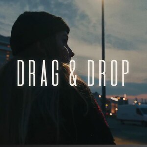 以下が含まれることがあります： 夕暮れ時の空を背景に、白字で「DRAG & DROP」と書かれたテキストが重ねられたシネマティックショット。クルーズ船とバン、ミニマルなウェブサイトナビゲーションバーも含まれています。