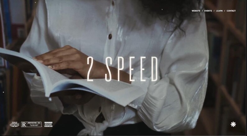 以下が含まれることがあります： 「2 SPEED」の文字が重ねられた、開いた本を持つ人物。白いボタンダウンシャツを着ています。背景はぼやけた本棚です。ウェブサイトのナビゲーションが上部に表示されています。