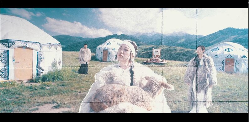 May include: A pastoral scene featuring people in traditional fur garments, standing near white yurts on a grassy field. One person holds a lamb. Mountains and a blue sky with clouds are in the background.