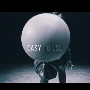 May include: A grayscale image features a large, spherical object held by a person. The text "EASY TO USE" is displayed on the sphere. The background is dark, creating a contrast with the bright sphere.