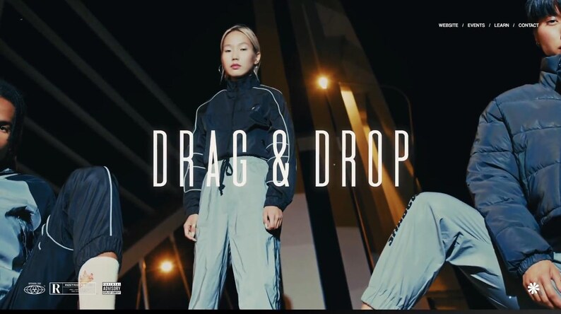 May include: A promotional image featuring three people wearing athletic wear. The central figure stands in light gray pants and a black jacket with white trim. The text "DRAG & DROP" is prominently displayed in white. The background is dark with architectural elements.