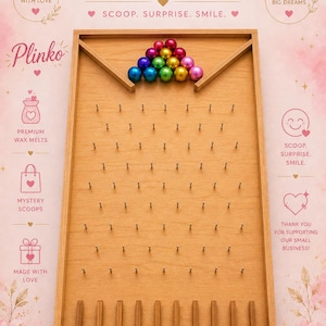 May include: A wooden Plinko game board featuring a light brown finish with a grid of metal pins and eight slots at the bottom. A pyramid of fifteen small, shiny, multi-colored metallic spheres is positioned at the top of the board.