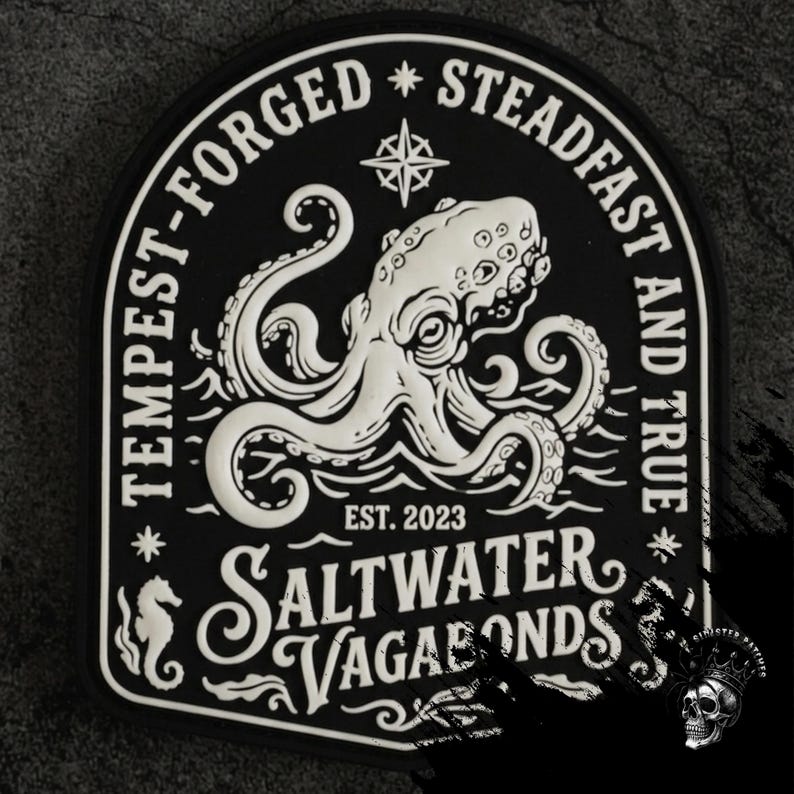 以下が含まれることがあります： タコのデザインが施された白黒のパッチ。「TEMPEST-FORGED STEADFAST AND TRUE」と「SALTWATER VAGABONDS EST. 2023」の文字。タツノオトシゴと羅針盤のバラも特徴です。
