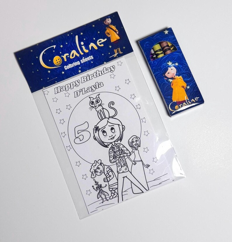 Op de afbeelding: Een kleurset met Coraline-thema in een doorzichtige plastic verpakking met een blauwe kopkaart met de tekst Coraline coloring sheets, inclusief een Happy Birthday D'Layla kleurplaat met personages en een klein doosje met kleurpotloden.