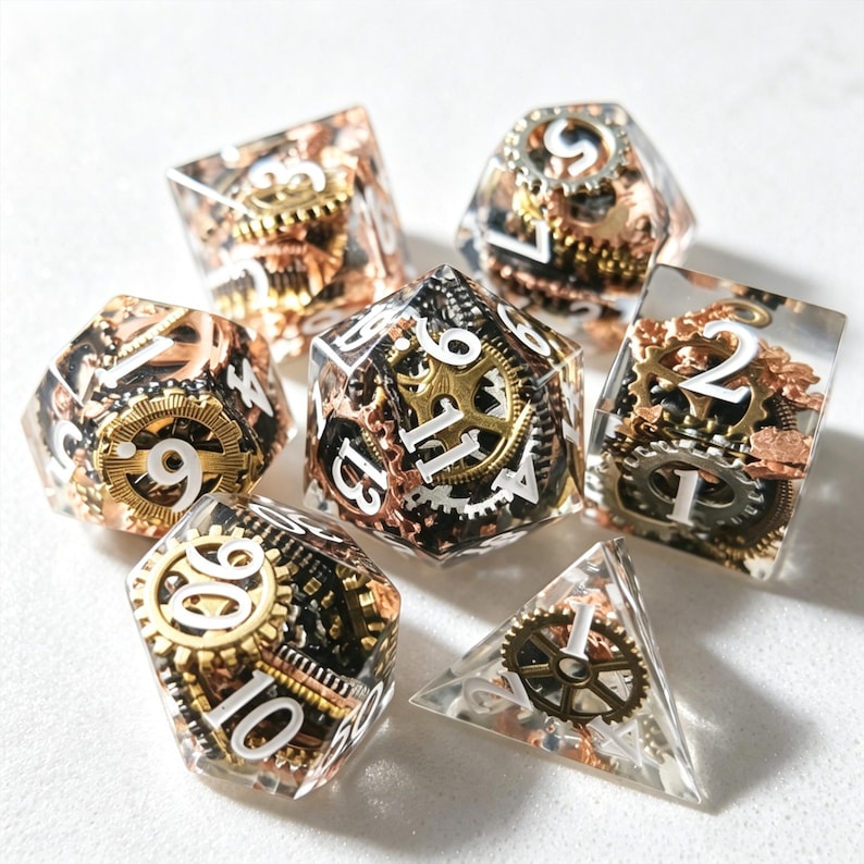 May include: Set of seven polyhedral dice with a steampunk aesthetic. Each die is clear with embedded gears in copper, silver, and gold tones. White numbers are visible on each face. The dice are designed for tabletop role-playing games.
