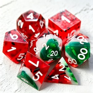 Può includere: Un set di sette dadi poliedrici con un design a forma di anguria. I dadi sono rossi con numeri bianchi e vortici verdi e bianchi, che ricordano la polpa e la buccia dell'anguria. Per giochi da tavolo.