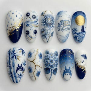May include: A set of ten painted fingernails with various designs in shades of blue, white, and gold. Designs include rain, cartoon characters, flowers, and a night sky. The nails are oval-shaped and have a glossy finish.