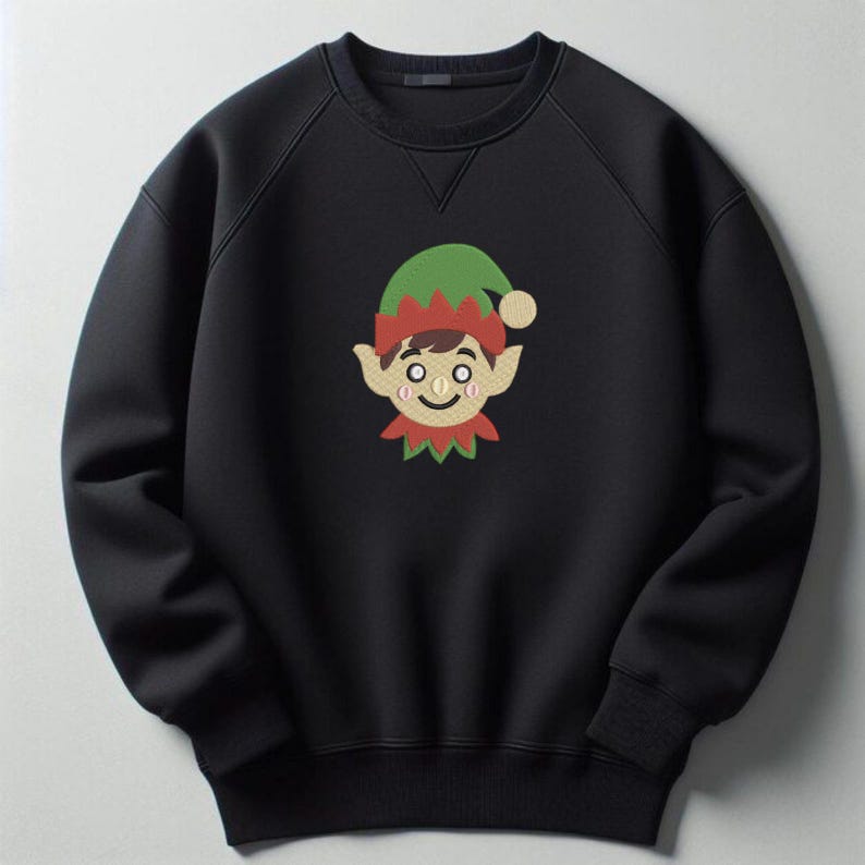 K&ouml;nnte beinhalten: Ein schwarzes Langarm-Sweatshirt mit einer mittig platzierten Stickerei eines Elfengesichts. Die Elfe tr&auml;gt eine gr&uuml;n-rote M&uuml;tze mit Bommel, hat spitze Ohren und einen roten Kragen. Das Sweatshirt verf&uuml;gt &uuml;ber einen Rundhalsausschnitt sowie gerippte B&uuml;ndchen.